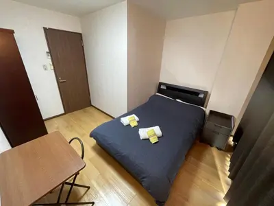 a small room with a bed and a table at \u8c4a\u5cf6\u5927\u585a\u685c\u6c11\u5bbf in Tokyo