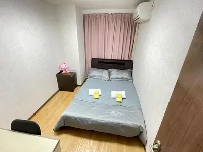 a small bedroom with a bed with two yellow folders at \u8c4a\u5cf6\u5927\u585a\u685c\u6c11\u5bbf in Tokyo