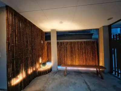 a bench in the corner of a room with a wall at \u6d45\u8349\u82d1 in Tokyo