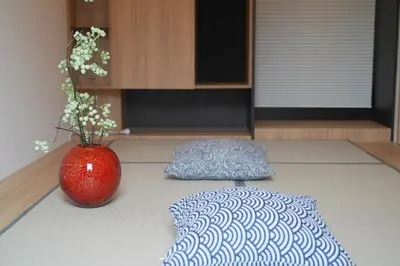 a red vase sitting on top of a floor next to a rug at \u6d45\u8349\u82d1 in Tokyo