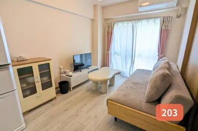 a room with a bed and a tv and a table at Arms Nishi-Shinjuku in Tokyo