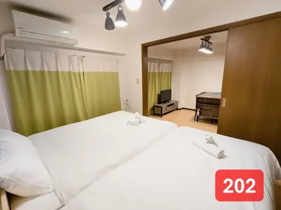 two beds in a bedroom with a sign that says at Arms Nishi-Shinjuku in Tokyo