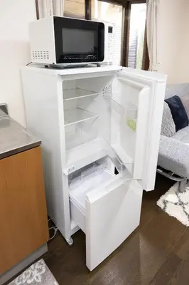 a white refrigerator with a microwave on top of it at \u5c0f\u5ca93LDK\u4e00\u8ed2\u5bb6 3 BDR House in Koiwa \u548c\u5fc3\u306e\u5bb6 in Tokyo