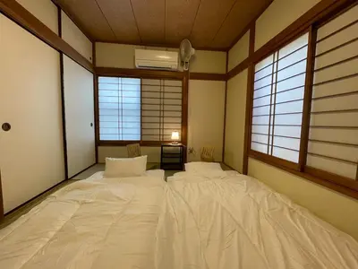 two beds in a room with two windows at \u5c0f\u5ca93LDK\u4e00\u8ed2\u5bb6 3 BDR House in Koiwa \u548c\u5fc3\u306e\u5bb6 in Tokyo