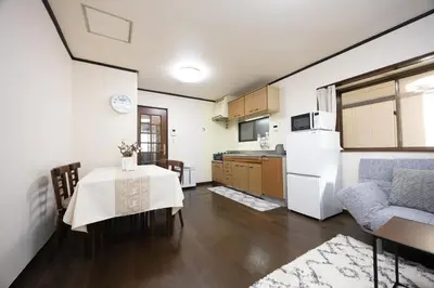 a kitchen with a table and a white refrigerator at \u5c0f\u5ca93LDK\u4e00\u8ed2\u5bb6 3 BDR House in Koiwa \u548c\u5fc3\u306e\u5bb6 in Tokyo