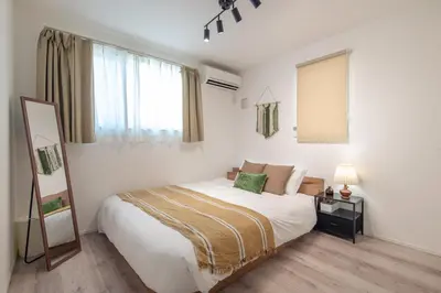 a white bedroom with a bed and a mirror at Mi-Villa SHIBUYA HONMACHI in Tokyo
