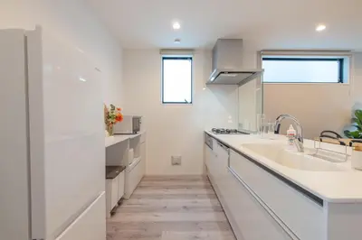 a white kitchen with a sink and a counter at Mi-Villa SHIBUYA HONMACHI in Tokyo