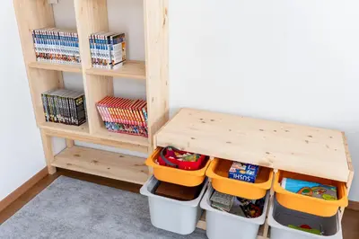 a organized playroom with a wooden shelf and buckets at ZEN HOTEL Haven in Tokyo