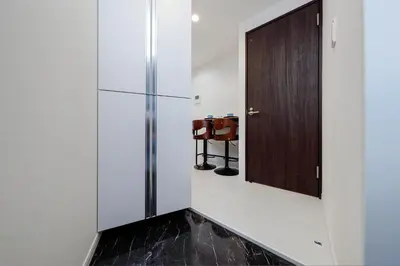 a kitchen with white walls and a wooden door at Lumiere de Zenith Shinagawa by Tranova in Tokyo
