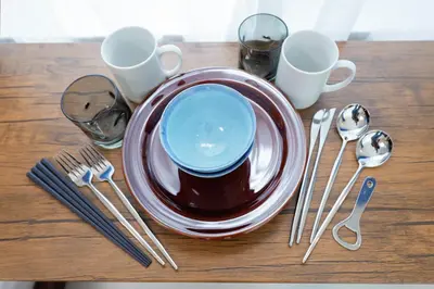 a table with a plate with a blue bowl and silverware at Lumiere de Zenith Shinagawa by Tranova in Tokyo
