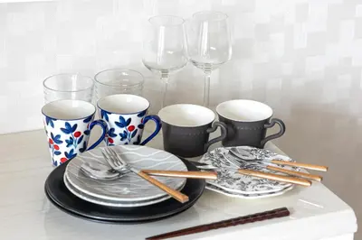 a table with plates and chopsticks and wine glasses at R STAY Oshiage 201 in Tokyo