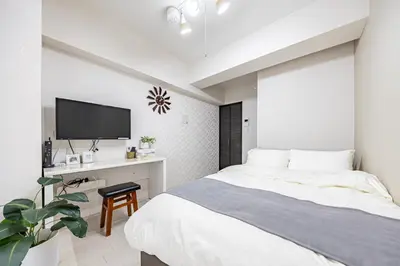 a bedroom with a bed and a desk with a tv at R STAY Oshiage 201 in Tokyo