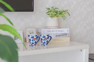 a shelf with two vases and a stack of books at R STAY Oshiage 201 in Tokyo