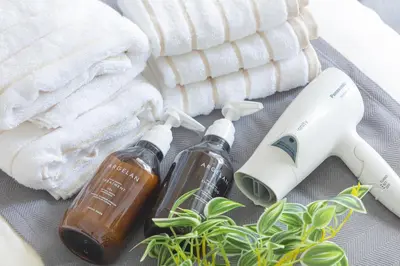 two bottles of essential oils and towels next to a plant at R STAY Oshiage 201 in Tokyo