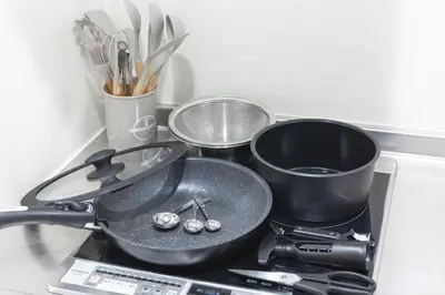 a stove top with two pans and tongs on it at R STAY Oshiage 201 in Tokyo