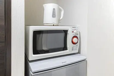 a microwave with a coffee cup on top of it at R STAY Oshiage 201 in Tokyo