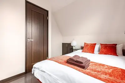 a bedroom with a large white bed with red pillows at jtr\u6771\u5927\u4e952\u4e01\u76ee in Tokyo