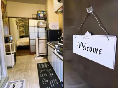 a sign that says welcome is hanging on a door at 202 Koiwa st private Room in Tokyo