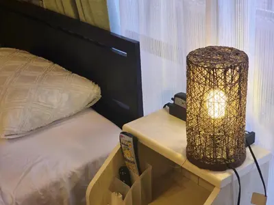 a bedroom with a bed and a lamp on a night stand at 202 Koiwa st private Room in Tokyo