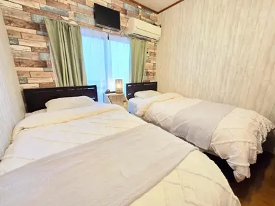 two beds in a room with a brick wall at 202 Koiwa st private Room in Tokyo