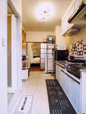 a kitchen with a counter and a room with a bed at 202 Koiwa st private Room in Tokyo