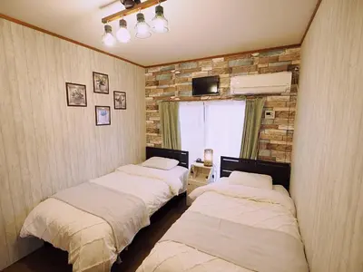 two beds sitting in a room with a window at 202 Koiwa st private Room in Tokyo