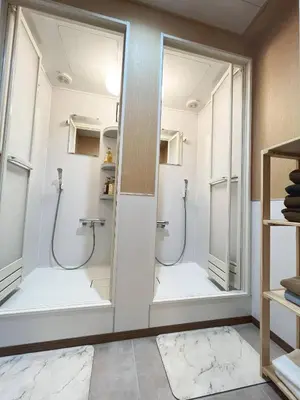 two mirrors in a bathroom with two showers at \u6771\u4eac\u6d45\u8349\u30a4\u30f3301 in Tokyo