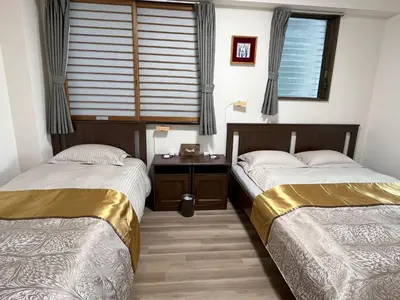 two beds in a room with a window at \u6771\u4eac\u6d45\u8349\u30a4\u30f3301 in Tokyo
