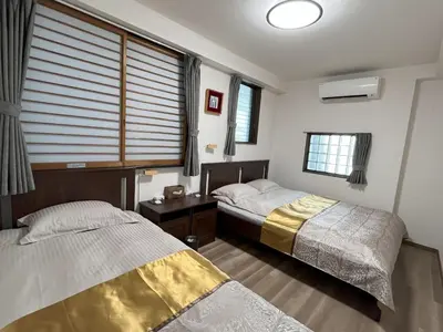 two beds in a room with a window at \u6771\u4eac\u6d45\u8349\u30a4\u30f3301 in Tokyo