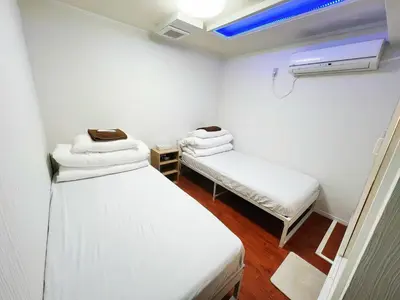 a small room with two beds and a heater at \u6e21\u8fb9\u30d3\u30eb103 in Tokyo