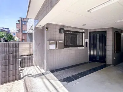 an outside view of a building with a black door at \u6e21\u8fb9\u30d3\u30eb103 in Tokyo