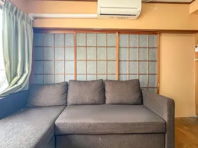 a couch sitting in a room with a window at \u6e21\u8fb9\u30d3\u30eb103 in Tokyo
