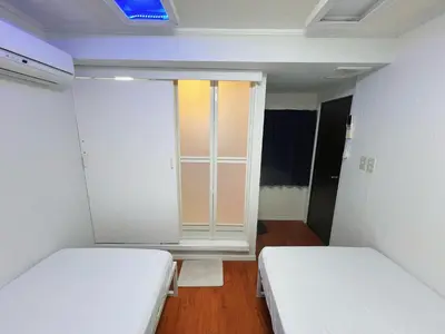 a small room with two beds and a window at \u6e21\u8fb9\u30d3\u30eb103 in Tokyo