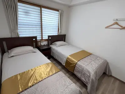 two beds in a room with a window at \u6771\u4eac\u6d45\u8349\u30a4\u30f3401 in Tokyo