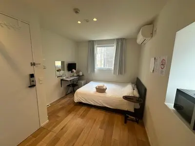 a small bedroom with a bed and a television at Ficus Tokyo in Tokyo