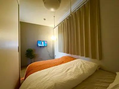a bedroom with a bed and a tv on a wall at ToyoHomes\u897f\u65b0\u5bbf in Tokyo
