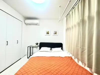 a bedroom with a bed with an orange rug at ToyoHomes\u897f\u65b0\u5bbf in Tokyo