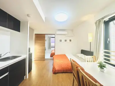 a room with a kitchen and a bedroom with a bed at ToyoHomes\u897f\u65b0\u5bbf in Tokyo
