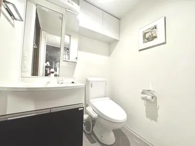 a white bathroom with a toilet and a sink at ToyoHomes\u897f\u65b0\u5bbf in Tokyo