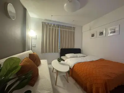 a bedroom with a bed and a table and a couch at ToyoHomes\u897f\u65b0\u5bbf in Tokyo
