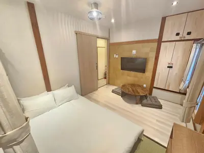 a room with a bed and a table and a tv at Nanayado Asakusa Okachimachi in Tokyo