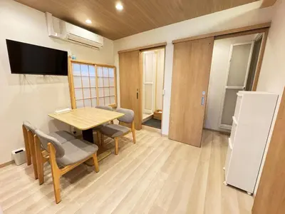 a room with a table and chairs and a television at Nanayado Asakusa Okachimachi in Tokyo