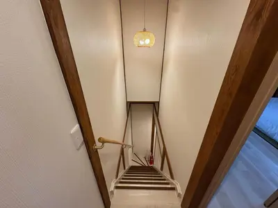 a hallway with a staircase with a light on the ceiling at Nanayado Asakusa Okachimachi in Tokyo