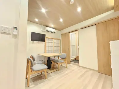 a room with a table and chairs and a tv at Nanayado Asakusa Okachimachi in Tokyo