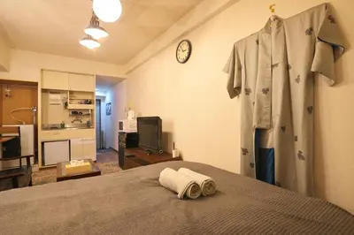a bedroom with a bed and a robe hanging on a wall at Zen Abode \u82b3 4 minutes walk from station cafe-like in Tokyo
