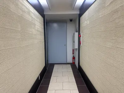a hallway with a door and a tile floor at West Shinjuku Nakano Family Inn in Tokyo