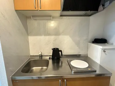 a small kitchen with a sink and a toilet at West Shinjuku Nakano Family Inn in Tokyo