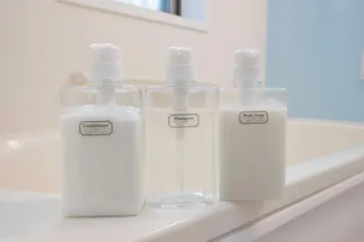 three plastic bottles sitting on a shelf in a bathroom at bai\u56db\u3064\u67282\u4e01\u76ee101 in Tokyo
