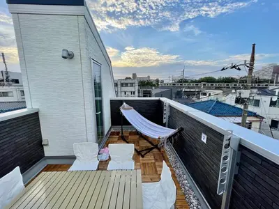 a balcony with chairs and a hammock on a building at Y-city house in Tokyo