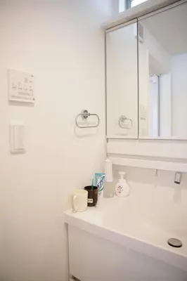 a white bathroom with a sink and a mirror at Y-city house in Tokyo